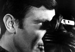 George Lazenby som James Bond håller kameran upp och ner spionkamera