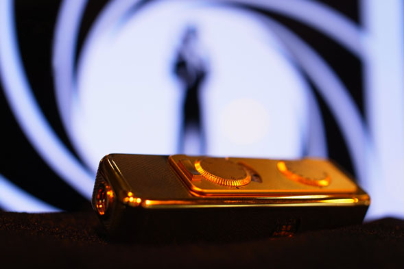 En guldpläterad upplaga av Minox AX, med den karaktäristiska James Bond agent 007-bilden i bakgrunden, utloppet av en pistolpipa. spionkamera